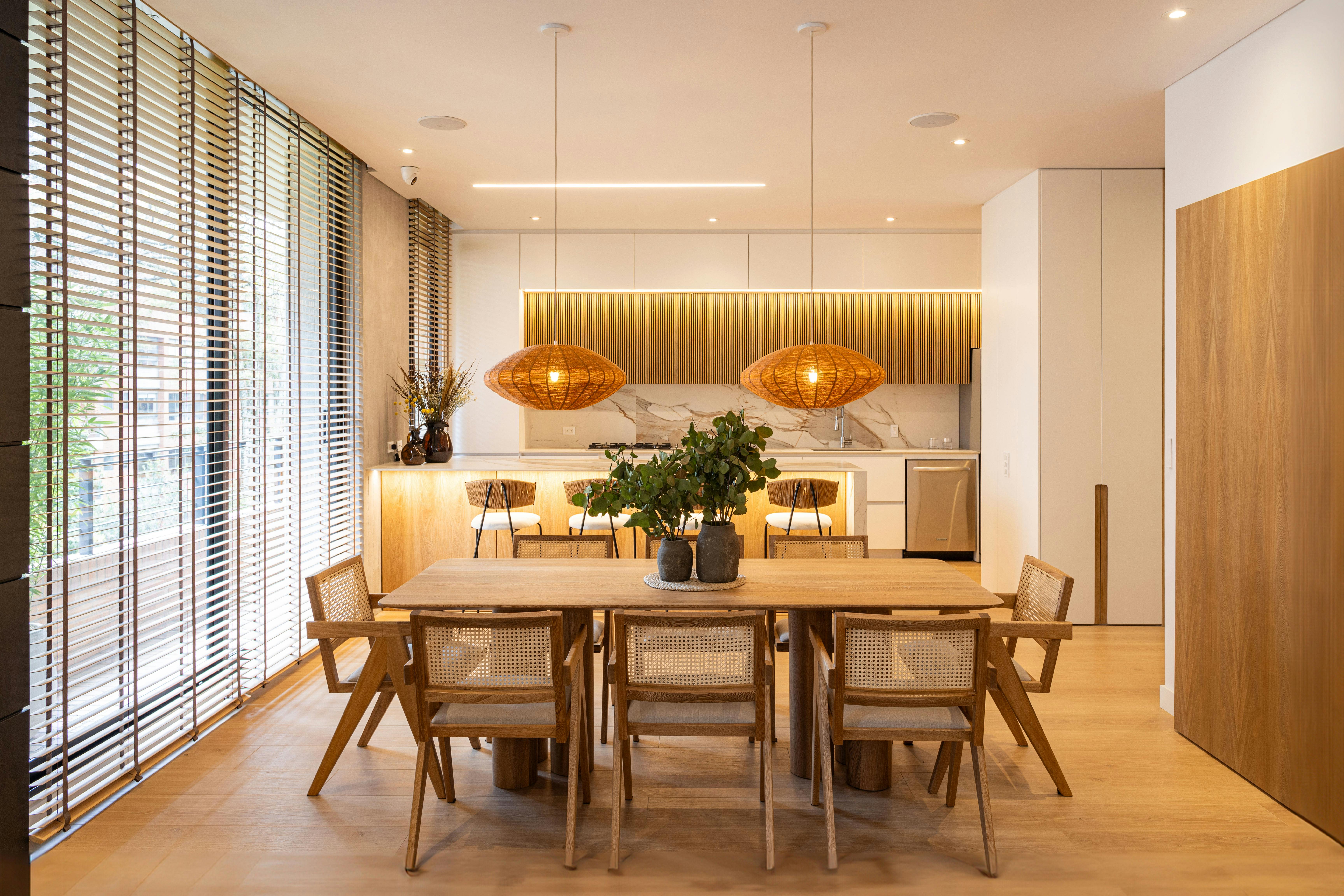 Elegant modern dining room featuring rattan chairs and wood accents in Bogotá, Colombia.
