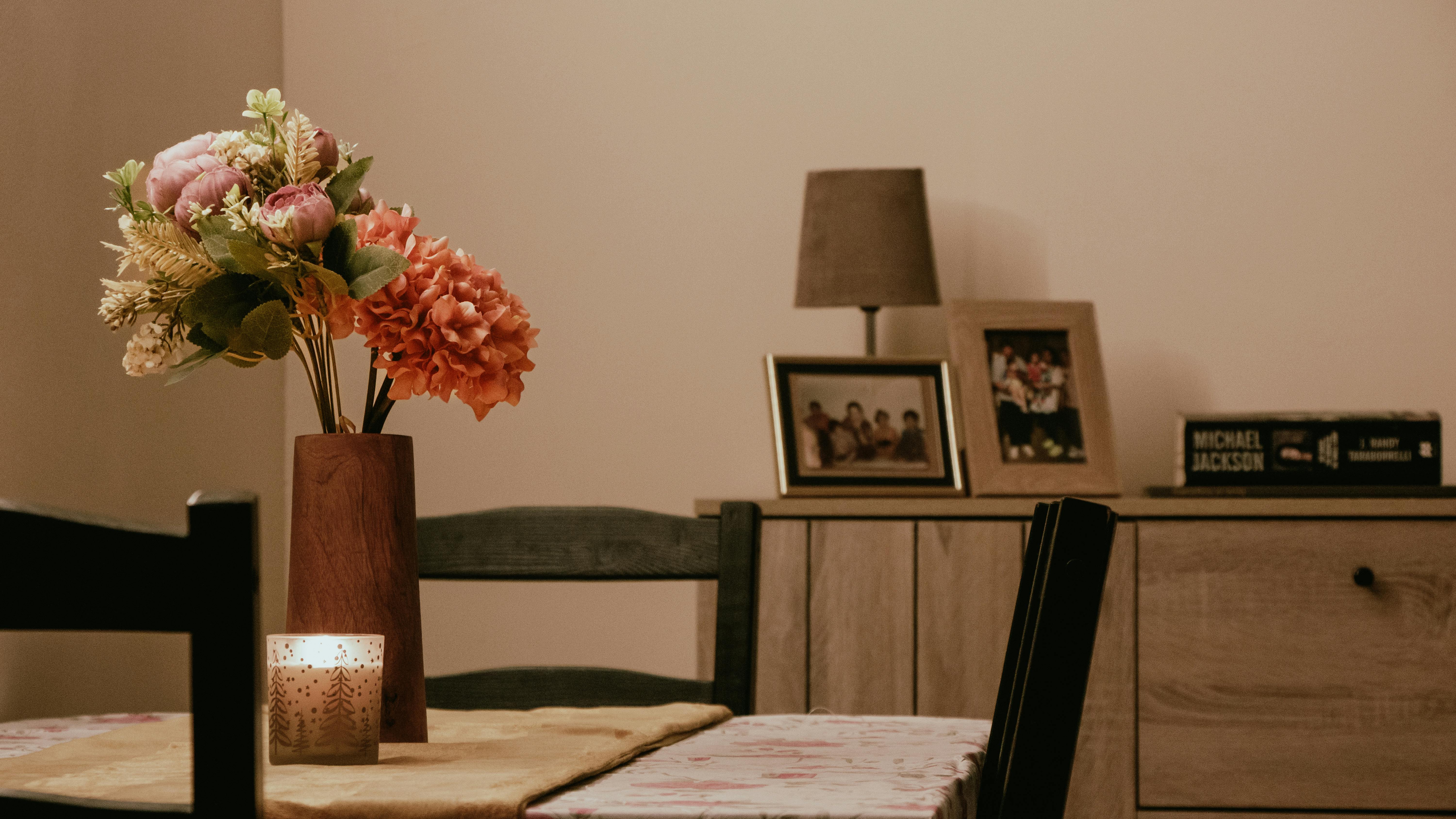 Elegant dining setup with flowers and candlelight in a cozy room.