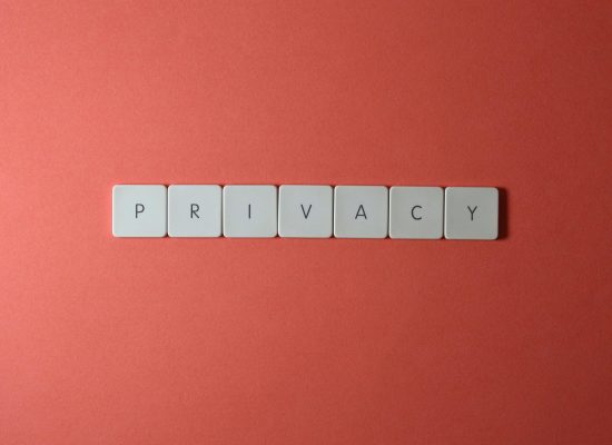 Close-up of letter tiles spelling PRIVACY on a red background, symbolizing data protection.