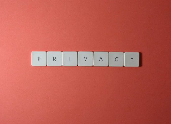 Close-up of letter tiles spelling PRIVACY on a red background, symbolizing data protection.